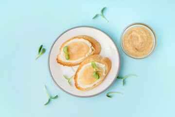 Delicious canape with caviar of capelin and microgreen on blue background