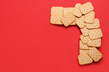 Frame made of tasty crackers on red background