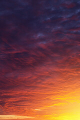 Epic dramatic sunset, sunrise on storm sky with dark clouds, orange yellow sun and sunlight