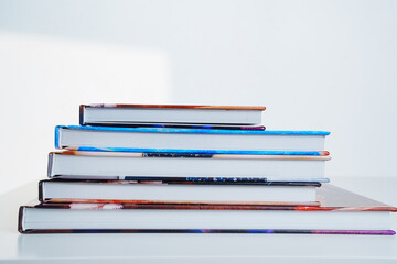 photobooks stacked on top of each other on a white table.