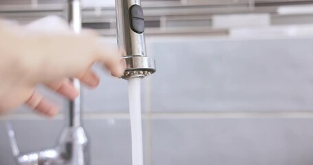 Changing the flow of tap water in a household faucet. - Powered by Adobe