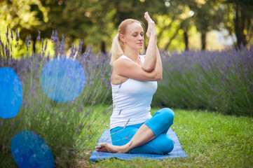 Woman practicing twisted yoga pose at the lavender garden
