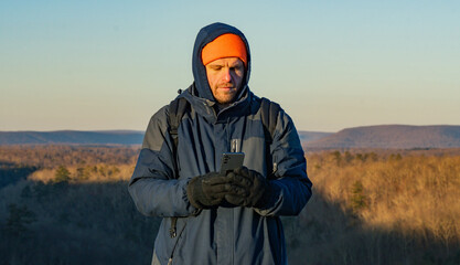winter season hiker taking a selfie or looking at his phone, lifestyle  