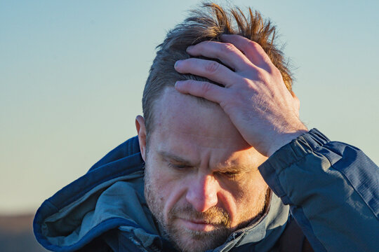depressed man holding his head angry mood