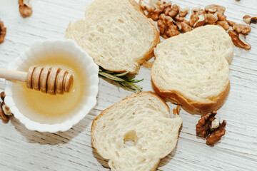 Fototapeta na wymiar Honey with white baguette toasts on kitchen wooden table.