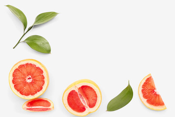 Composition with pieces of grapefruit and plant leaves on white background