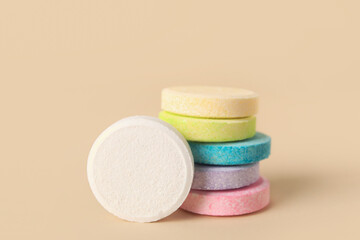 Obraz na płótnie Canvas Stacks of colorful soluble tablets on beige background