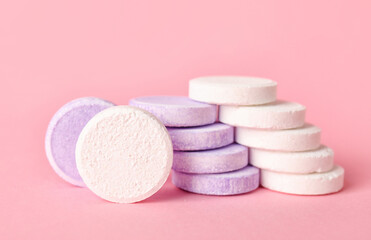 Obraz na płótnie Canvas White and lilac soluble tablets on pink background