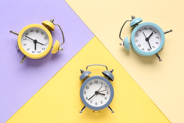 Vintage alarm clocks on color background