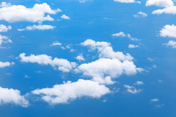 White clouds over the blue sea . Flying over the sea