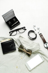 Composition with stylish male accessories, shirt and mobile phone on light background