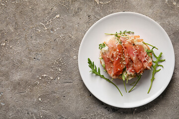 Plate of tasty bruschettas with ham on grunge background