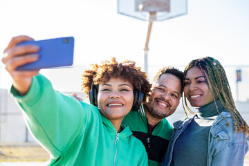 A group of happy and diverse multi-ethnic friends gather together on a basketball court. The 2...