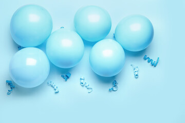 Blue balloons, ribbons and serpentine on color background