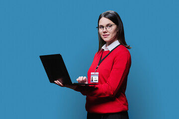 Young woman with educational center badge laptop on blue background
