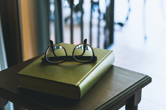 Framed eyeglasses on green book