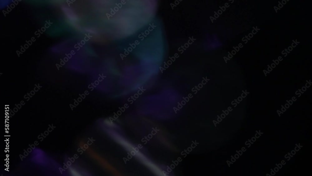 Wall mural blue, mint and purple bokeh moving background. shimmering motion of bokeh on black. defocused circle