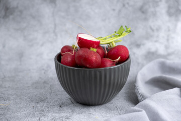 fresh radish in a plate on a gray background