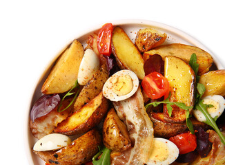 Plate of tasty potato salad with eggs, tomatoes and bacon isolated on white, closeup