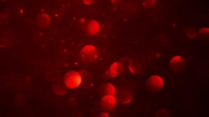 Shimmering red bokeh and dust particles motion. Abstract background of moving red blurred circles. Bokeh Lights in red.