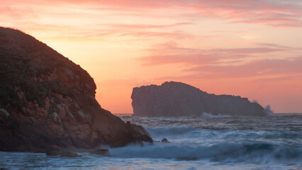 Paisaje de mar con las olas rompiendo sobre la costa en un atardecer
