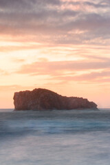 Fototapeta na wymiar Paisaje de mar con las olas rompiendo sobre la costa en un atardecer