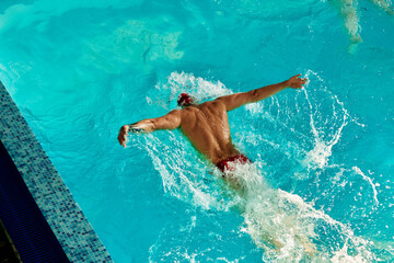 A male swimmer is training in the pool, a top view of a swimmer swimming along the track in the pool.