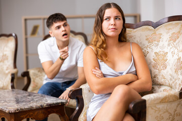 Young husband is dissatisfied with the act of his wife, scolding her for it and pointing out her...