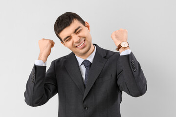Happy young businessman on light background