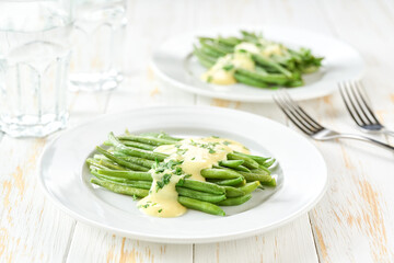green bean with mushroom sauce on white table, selective focus.