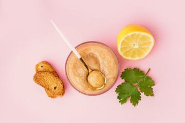 Glass with delicious caviar of capelin and croutons on pink background