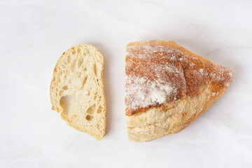 Sliced loaf of fresh bread on white table