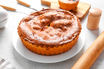 Plate with delicious meat pie on white grunge table
