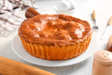 Plate with delicious meat pie on white grunge table