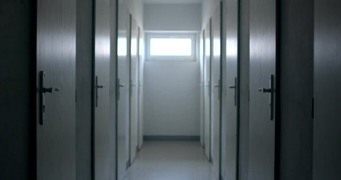 Camera movement in the basement of the hospital storage of items, warehouse by cells. outdoor light at the end of the tunnel window.