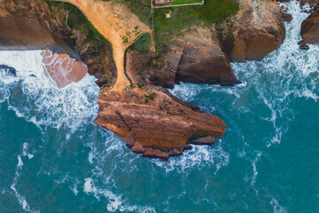 Waves splashing rocky coastline. Aerial view of sea waves and fantastic Rocky coast. Aerial view to ocean waves. Blue water background. 