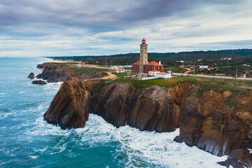 White lighthouse on cliffs at algarve portugal. panorama of beach in Portugal, cliffs and...