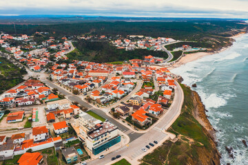 Fototapeta premium Beautiful view of an ocean with the rocky shore in Madeira, Portugal. Aerial shot of the rocky shore against the azure sea in Algarve, Portugal. 