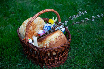 Fototapeta na wymiar Easter basket with holiday food on the grass