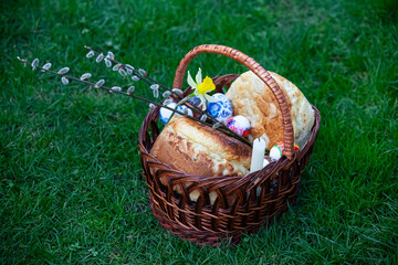 Easter basket with holiday food on the grass