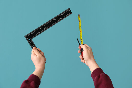 Worker with ruler and measure tape on blue background