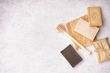Composition with natural soap bars and honey dipper on light background