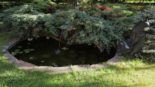 Beautiful small decorative pond with a small waterfall in the park