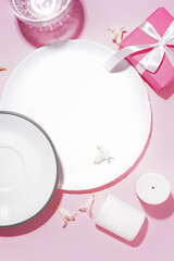 Composition with clean plates, beautiful hyacinth flowers and gift box on pink background