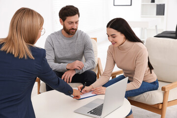 Couple signing contract in real estate agent's office