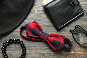 Set of male accessories with stylish bow tie on wooden background, closeup