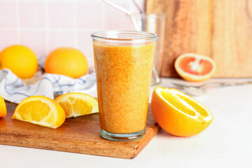 Glass of healthy orange smoothie on table