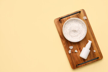 Wooden board with jar of body scrub and cosmetic product on color background