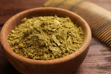 Bowl of henna powder on wooden table, closeup