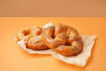 Baking paper with tasty pretzels on color background